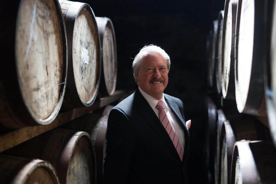 Richard Paterson con las barricas en las que envejece el whisky