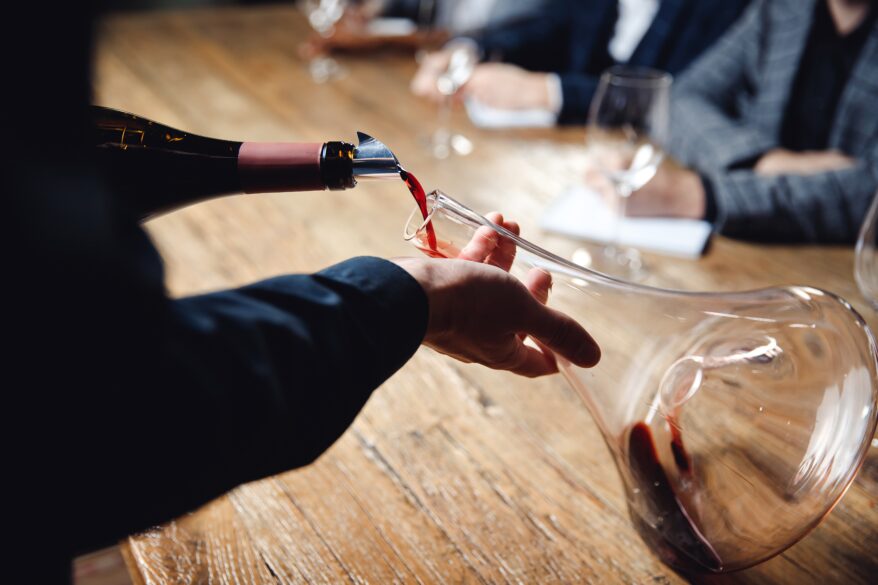 Defectos del vino: sumiller decantando una botella de vino tinto