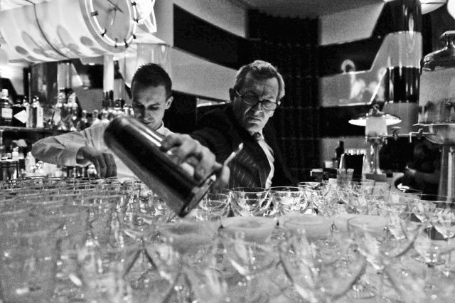 Dick Bradsell con la coctelera vertiendo un elixir sobre copas de martini