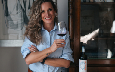 Alba Abiega con una copa de vino y una botella de Alba en Ribera